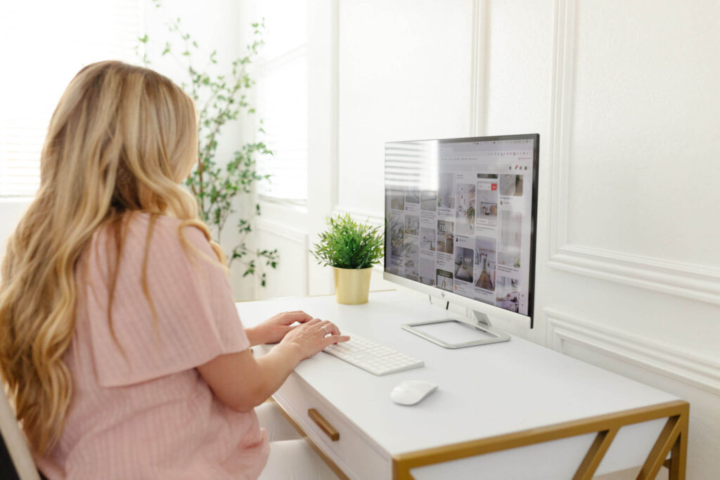 Woman on a computer at her desk, looking over her email and following links to different websites. 